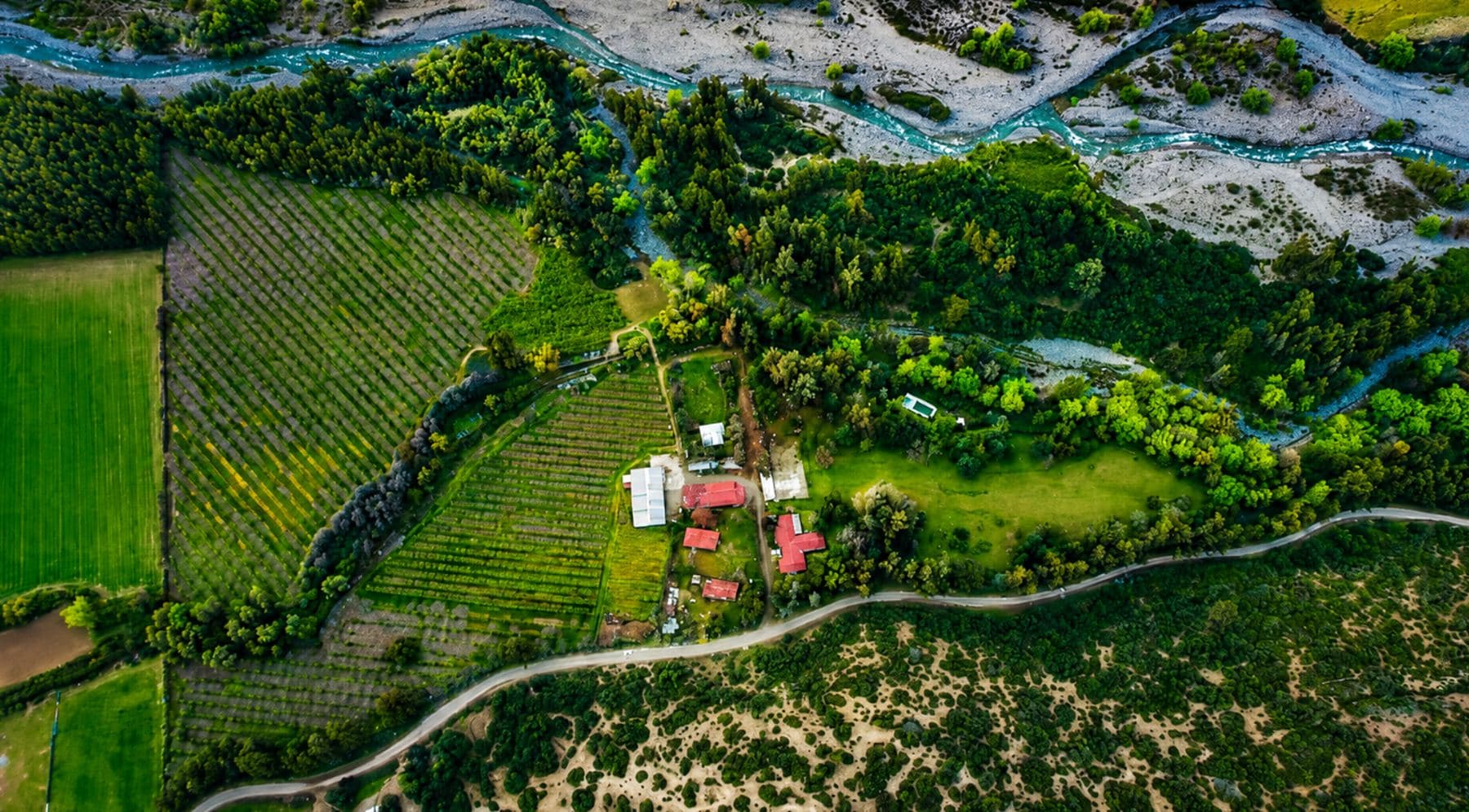 Vista aérea del predio de Puerto Rodante junto al Estero Codegua, entre parcelas verdes y la precordillera