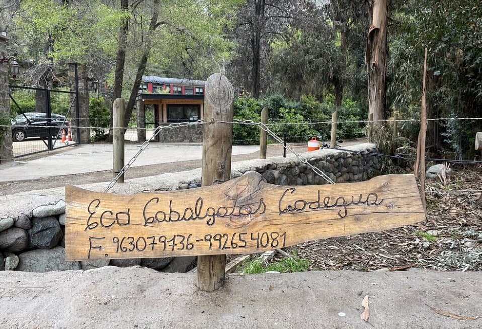 Letrero de madera tallada de Eco Cabalgatas Codegua a la entrada del predio